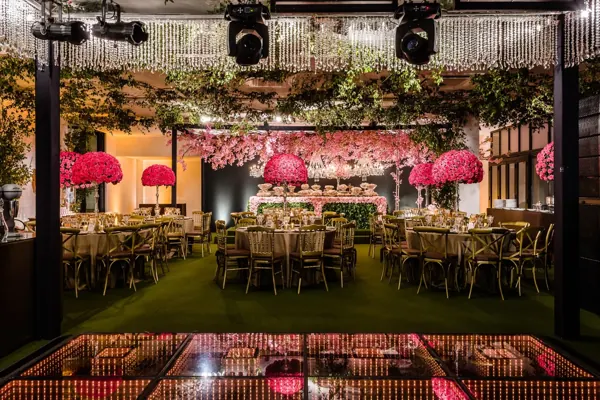 Salão com lustres e flores para festa de 15 anos
